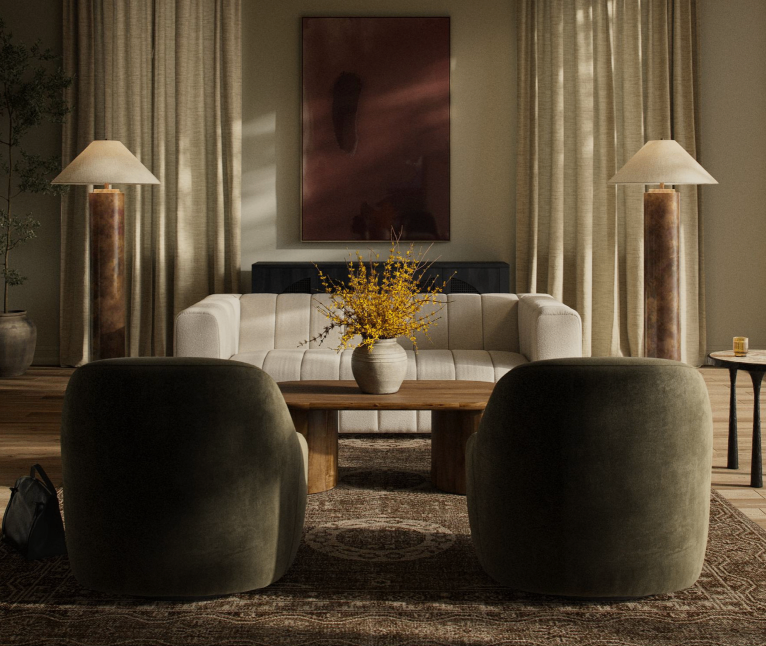 A designer leaning against a long linen-dressed dining table in soft daylight.